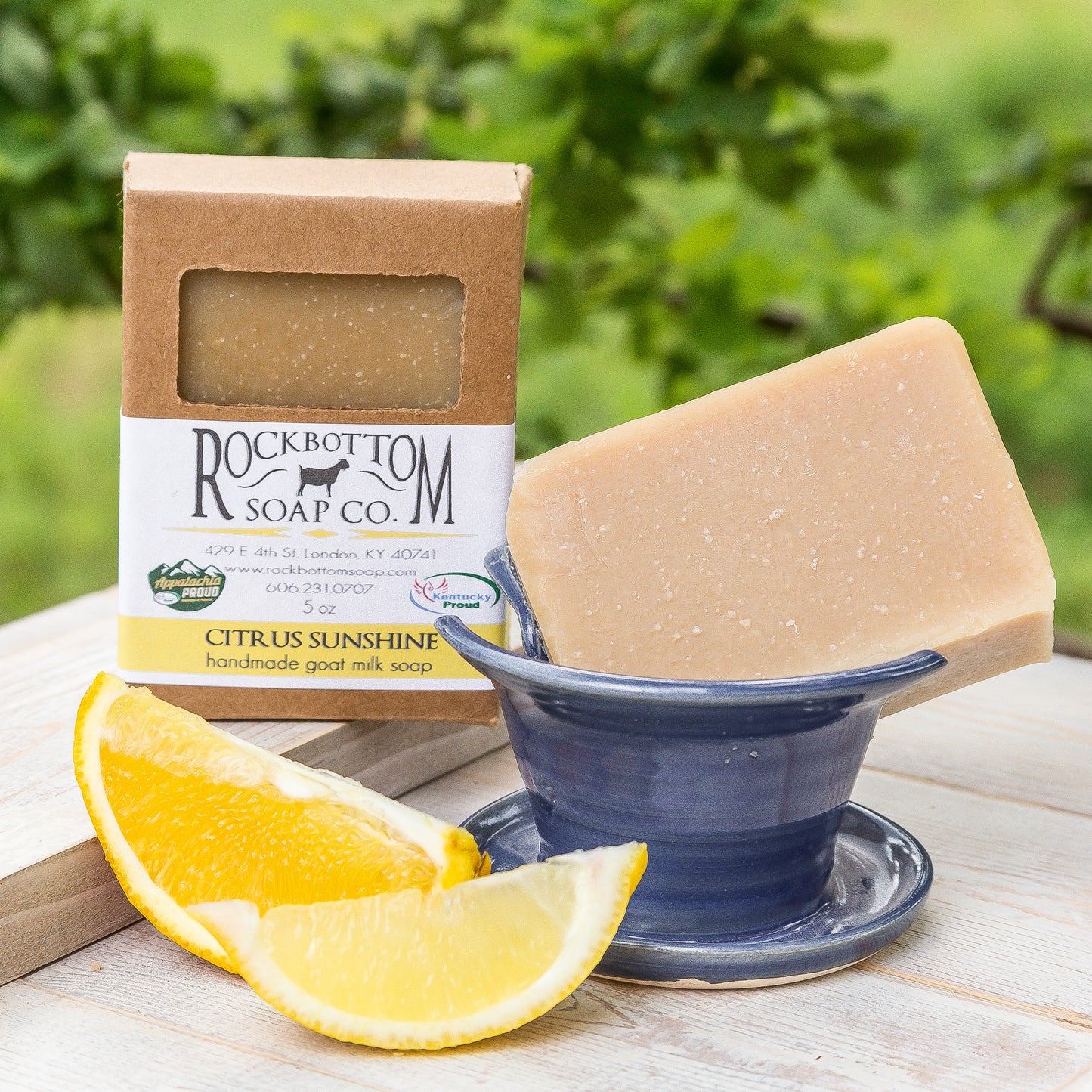 Citrus Agave Goat Milk Soap on a handmade pottery soap dish with green foliage background – bright, juicy citrus artisan soap