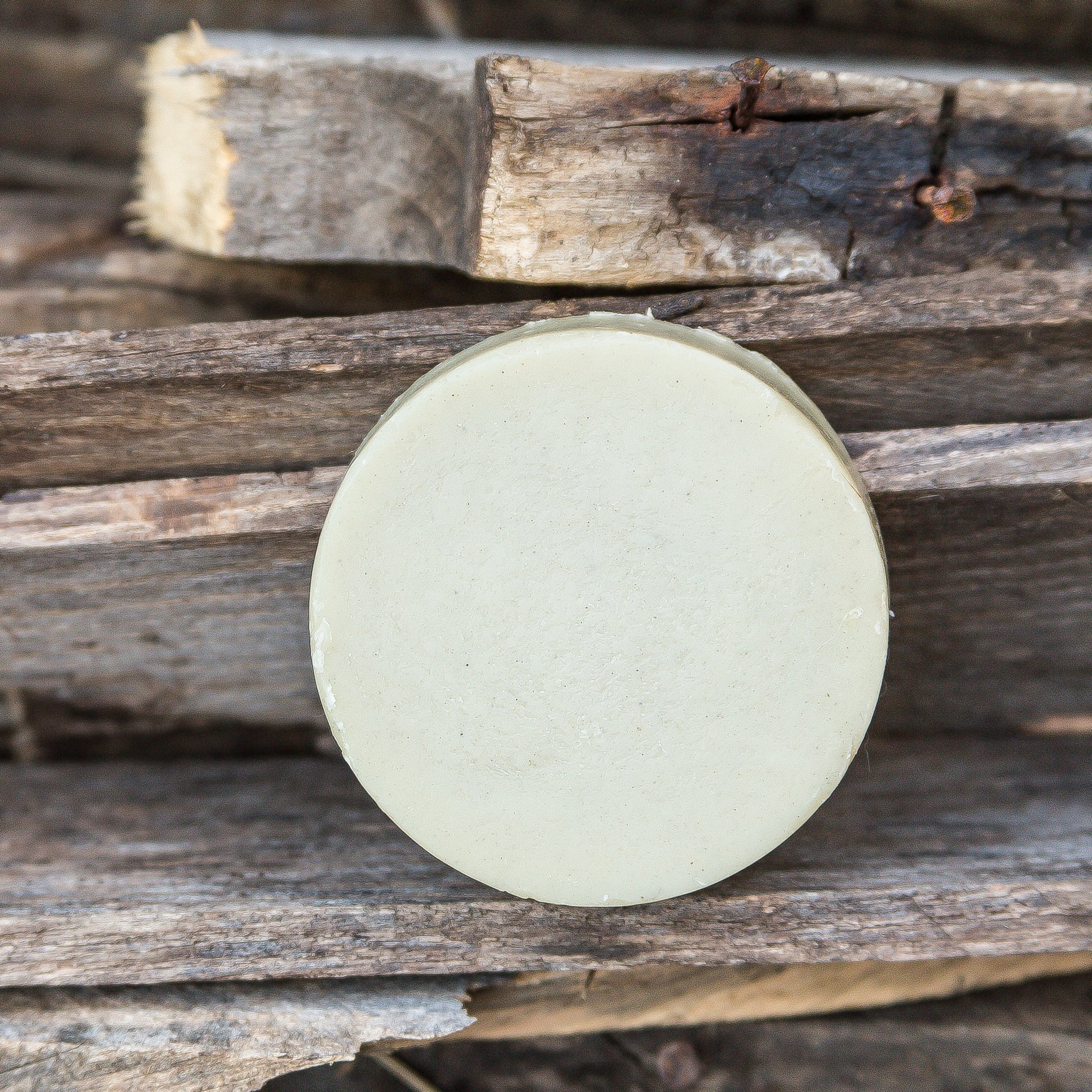 3 oz round shave soap puck made with goat milk and bentonite clay – natural lathering soap for traditional wet shaving, displayed on a wooden surface