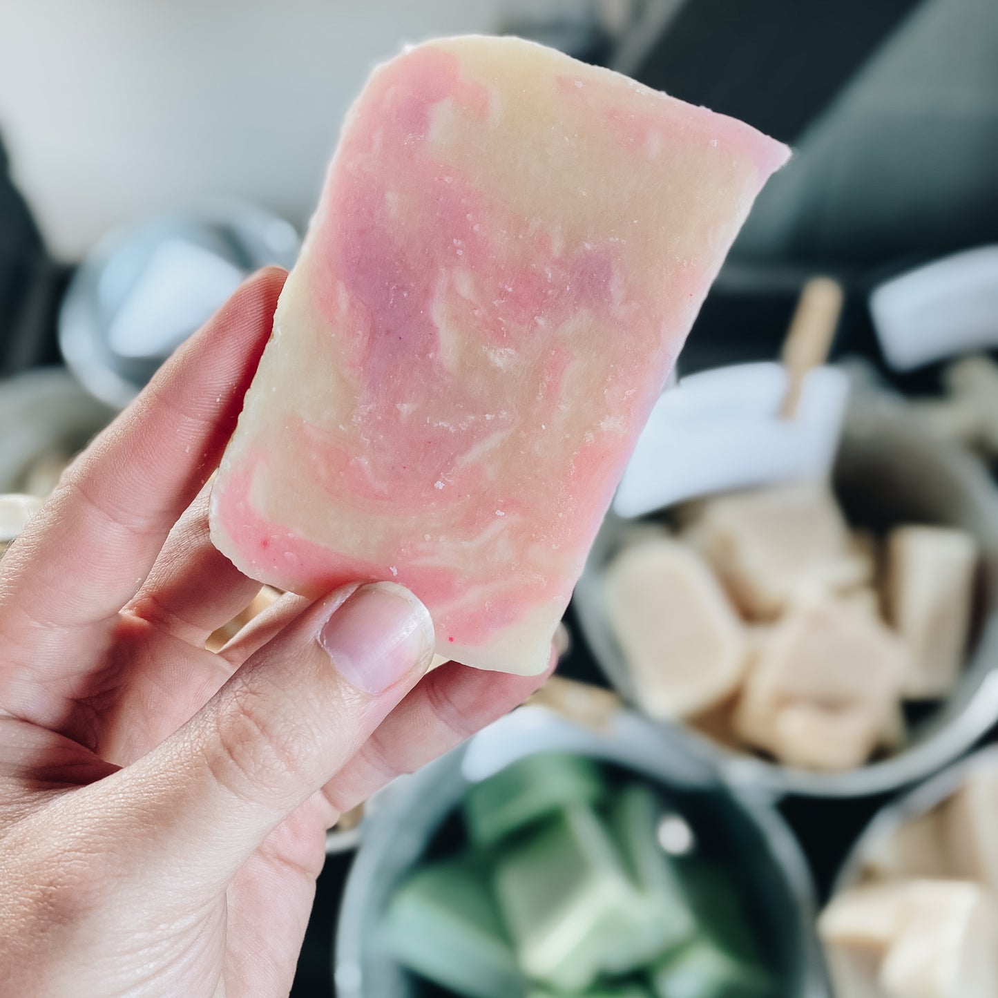 Unwrapped Goat Milk Soap Bar held above a box of more unwrapped bars – natural, handmade soap with a rustic, farm-fresh presentation