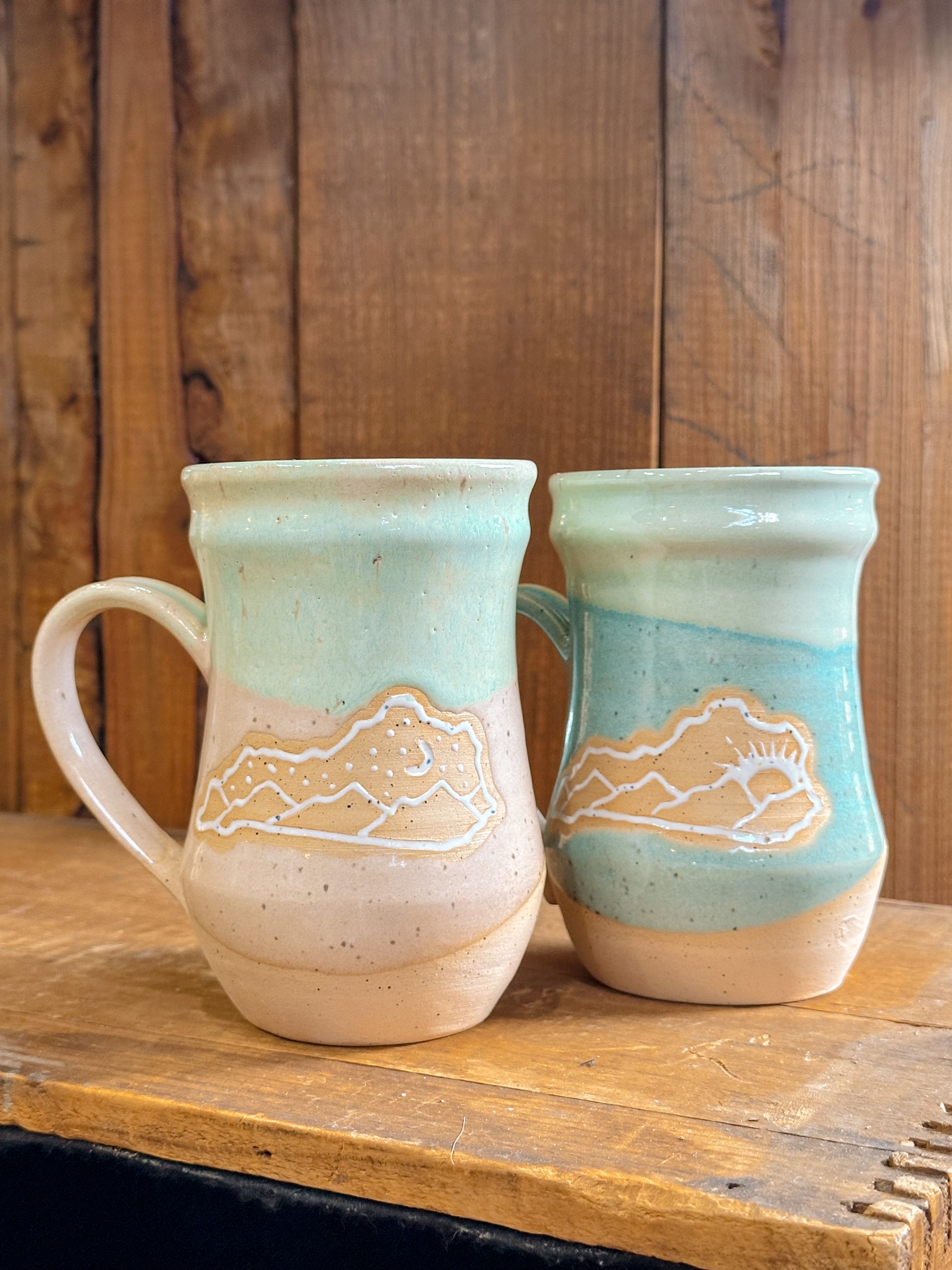 Variety of handmade Slab & Cedar mugs with Kentucky mountains etched on the side – ceramic drinkware inspired by Appalachian landscapes.